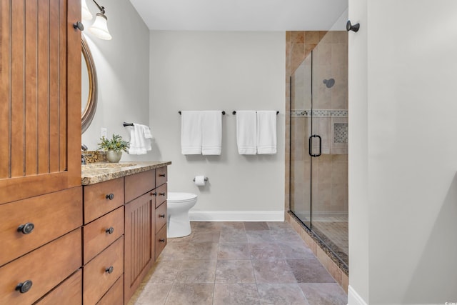 bathroom with vanity, toilet, and a shower with door