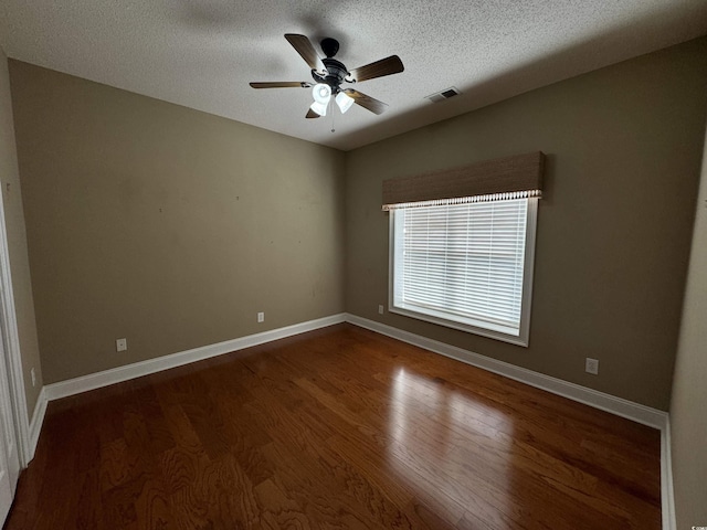 empty room featuring a textured ceiling, ceiling fan, and dark hardwood / wood-style floors