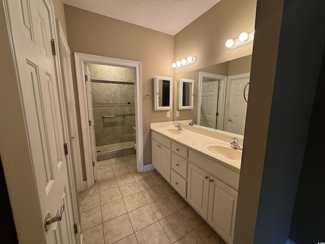 bathroom featuring tile patterned floors, vanity, an enclosed shower, and a textured ceiling