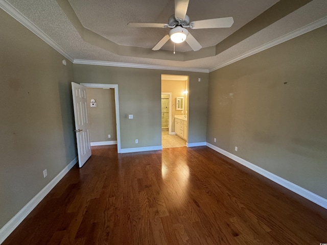 unfurnished bedroom featuring hardwood / wood-style floors, a raised ceiling, ceiling fan, and ornamental molding