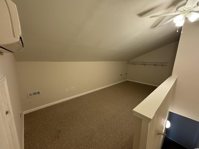 bonus room featuring an AC wall unit, ceiling fan, dark carpet, and vaulted ceiling