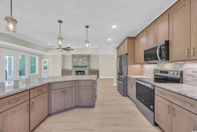2515 Saint Andrews Dr, Little River, SC 29566 - kitchen featuring stainless steel appliances, ceiling fan, decorative backsplash, a stone fireplace, and pendant lighting