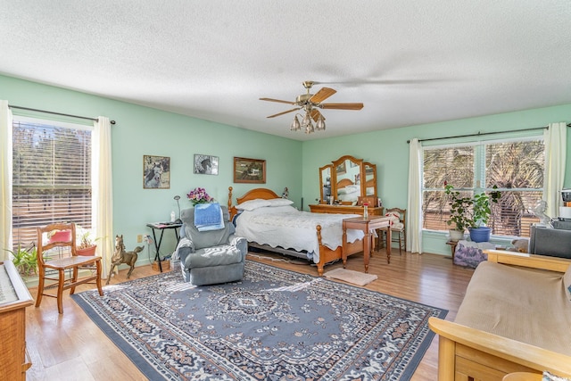 1692 S Morgan Ave, Andrews, SC 29510 - bedroom featuring multiple windows, a textured ceiling, light wood finished floors, and ceiling fan