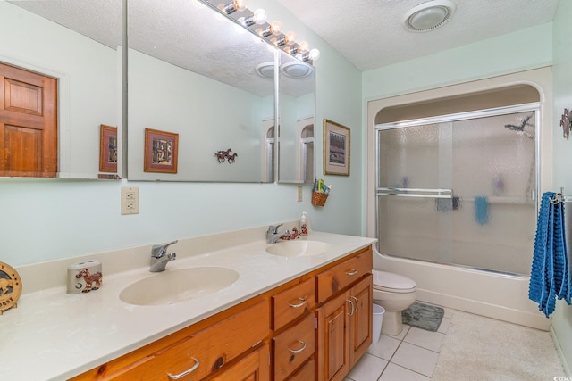 1692 S Morgan Ave, Andrews, SC 29510 - full bathroom featuring double vanity, toilet, tile patterned flooring, bath / shower combo with glass door, and a textured ceiling