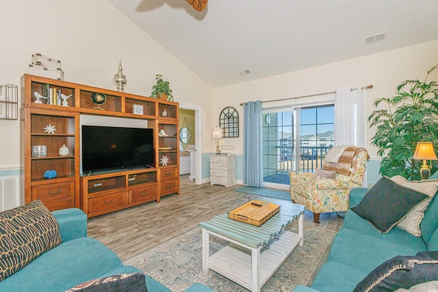 living room with light hardwood / wood-style flooring, high vaulted ceiling, and ceiling fan