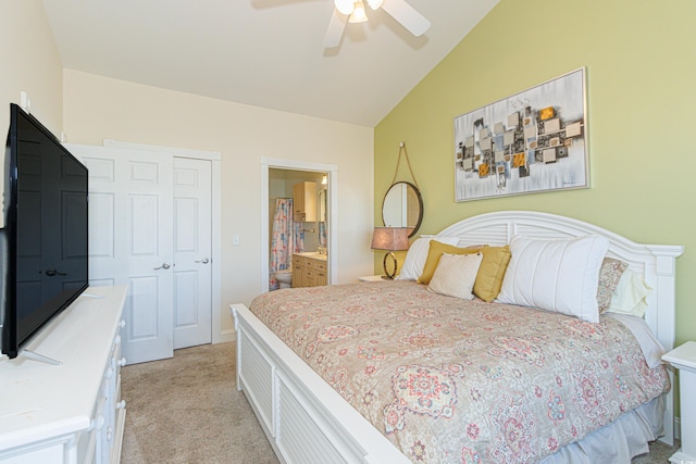 bedroom with vaulted ceiling, light carpet, ceiling fan, and ensuite bathroom