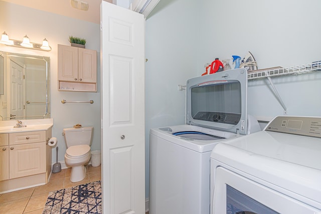 laundry area with washing machine and dryer and light tile patterned floors