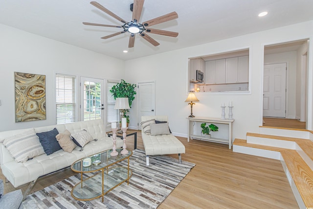 living room with ceiling fan and light hardwood / wood-style flooring