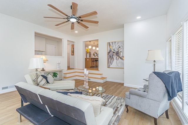 living room featuring ceiling fan, a healthy amount of sunlight, and light wood-type flooring