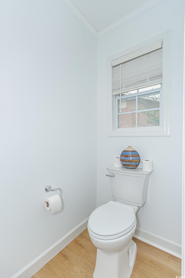 bathroom featuring hardwood / wood-style flooring, toilet, and crown molding