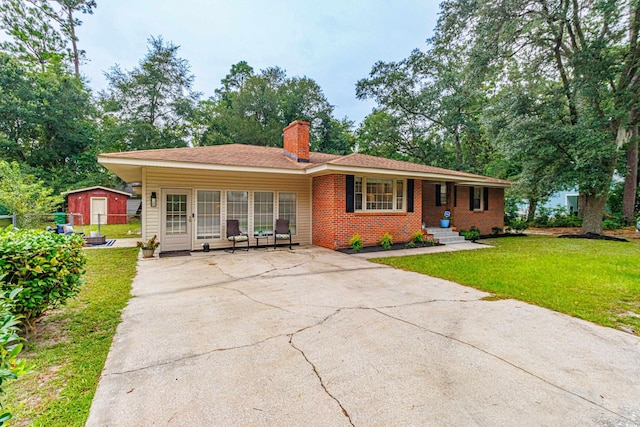 ranch-style home with a front lawn and a storage unit