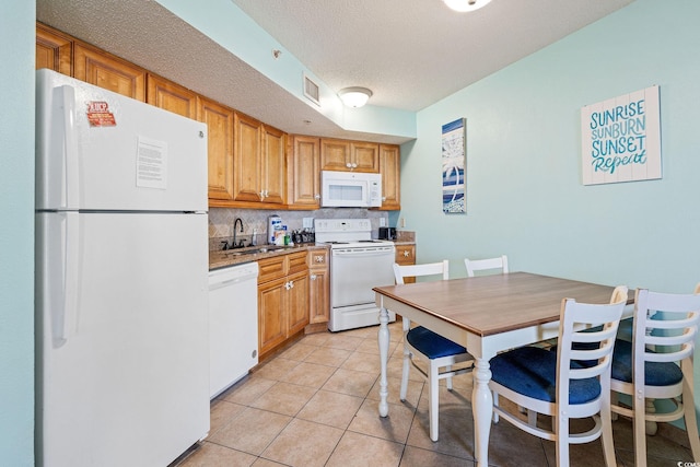 kitchen featuring backsplash, a textured ceiling, white appliances, sink, and light tile patterned flooring