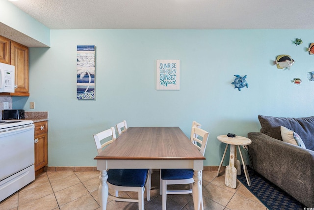 tiled dining area with a textured ceiling