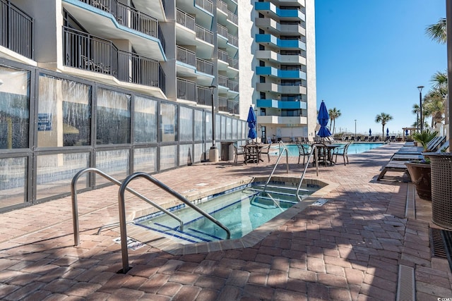 view of pool featuring a patio and a hot tub