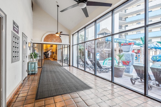 hall with tile patterned flooring and high vaulted ceiling