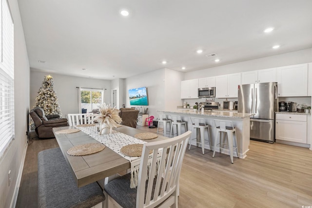 dining room with sink and light hardwood / wood-style floors