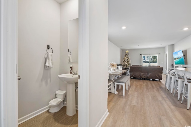 bathroom with hardwood / wood-style flooring, toilet, and sink