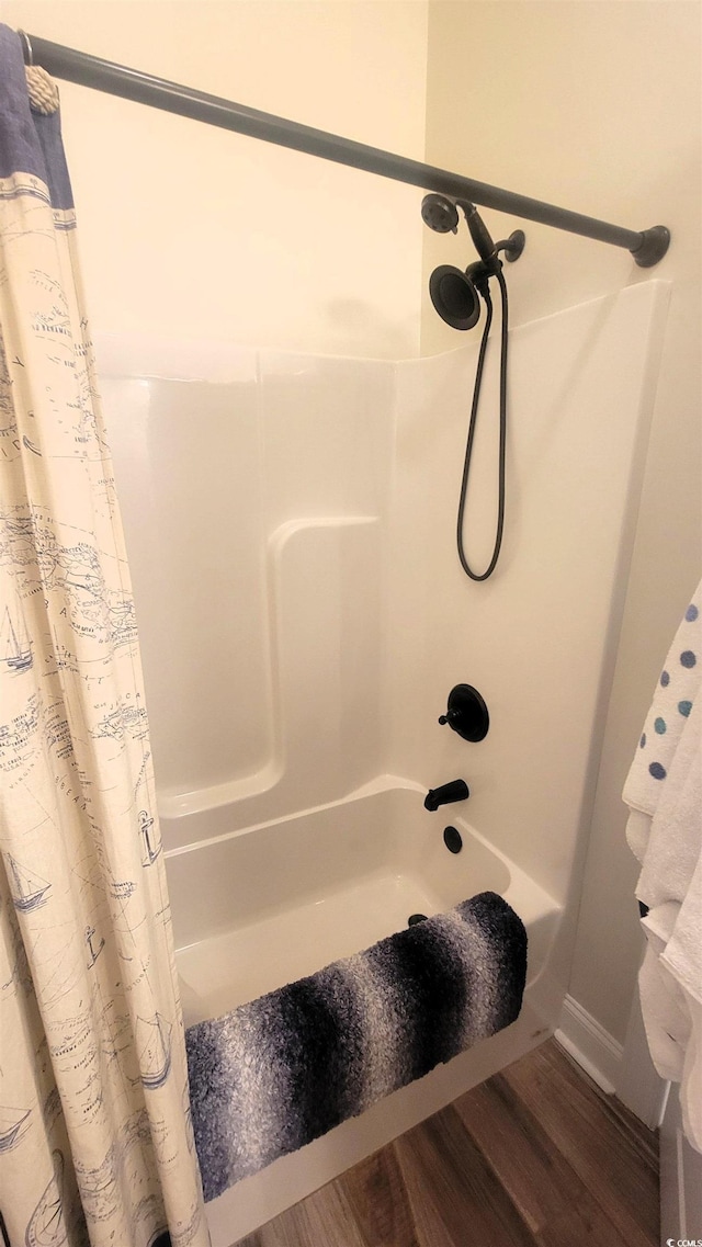 bathroom featuring hardwood / wood-style flooring and shower / bath combination with curtain