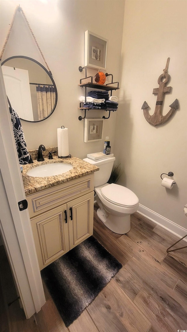 bathroom with hardwood / wood-style floors, vanity, and toilet