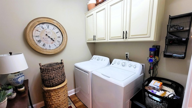 clothes washing area featuring cabinets, washing machine and dryer, and dark wood-type flooring