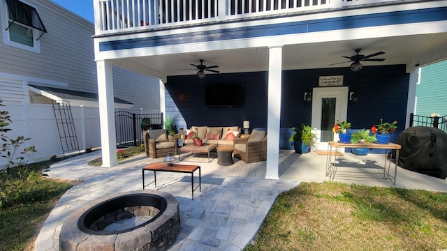 view of patio / terrace with a grill, ceiling fan, a balcony, and an outdoor living space with a fire pit