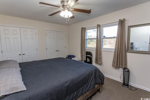 carpeted bedroom featuring ceiling fan and two closets