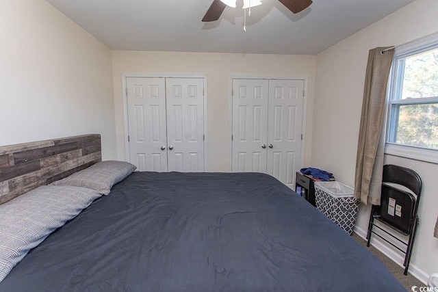 bedroom with carpet, ceiling fan, and multiple closets