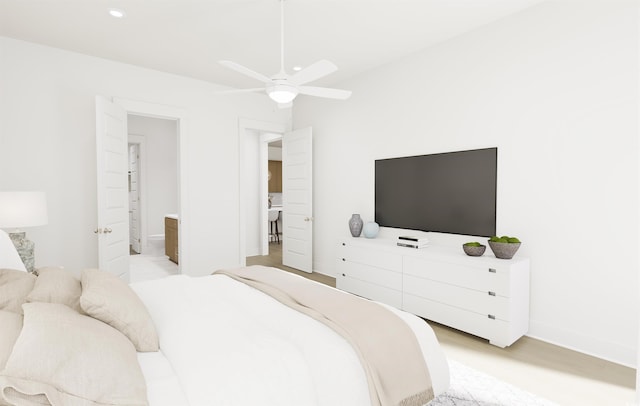 bedroom with ceiling fan, connected bathroom, and light hardwood / wood-style floors