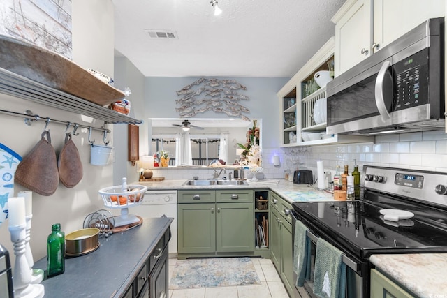 kitchen featuring green cabinets, ceiling fan, sink, and appliances with stainless steel finishes