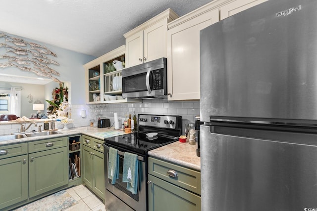 kitchen featuring backsplash, a textured ceiling, stainless steel appliances, sink, and light tile patterned floors