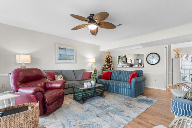 living room with wood-type flooring and ceiling fan