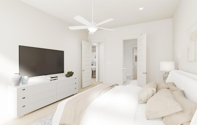 bedroom with ensuite bath and light hardwood / wood-style flooring