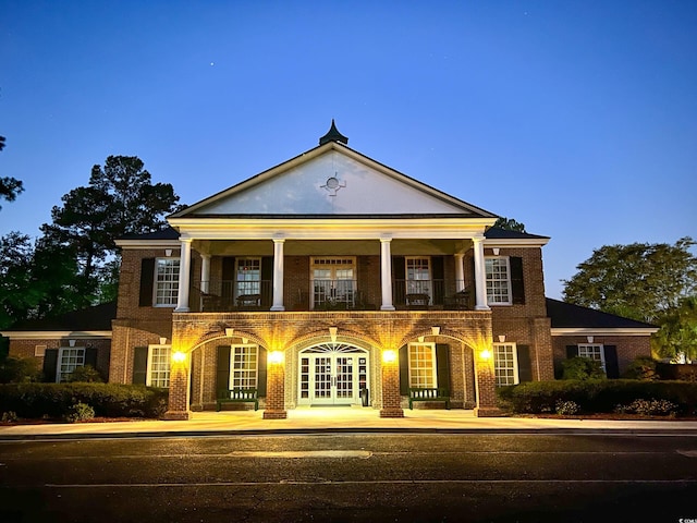 greek revival house featuring french doors and a balcony