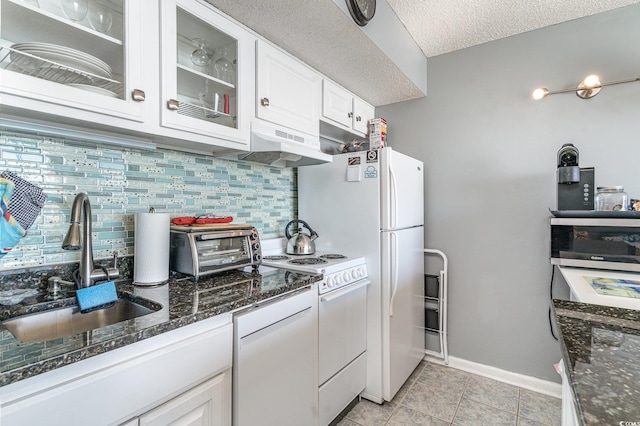 kitchen featuring ventilation hood, white range oven, white cabinetry, and tasteful backsplash