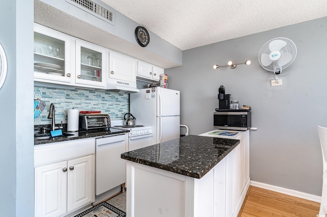 kitchen with white appliances, sink, a textured ceiling, tasteful backsplash, and white cabinetry