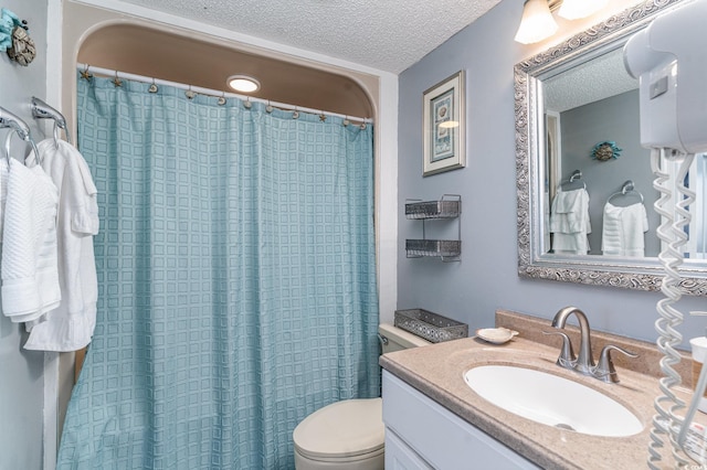 bathroom featuring a textured ceiling, vanity, toilet, and a shower with curtain