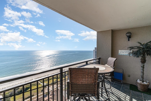 balcony featuring a view of the beach and a water view