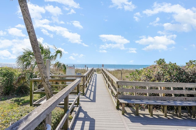 dock area featuring a water view and a beach view