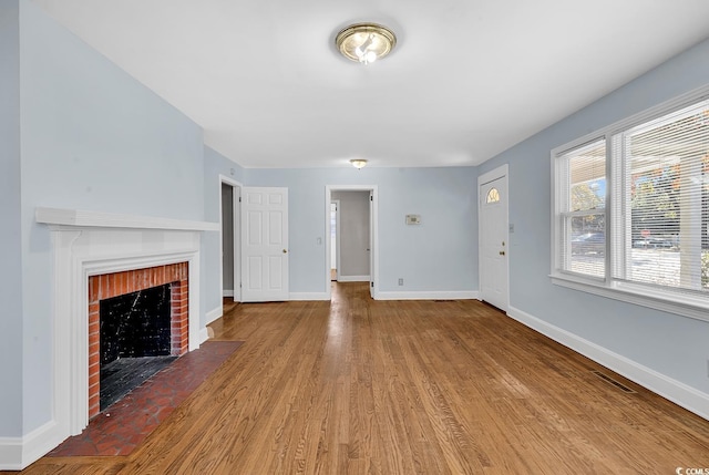 unfurnished living room featuring a fireplace and light hardwood / wood-style floors