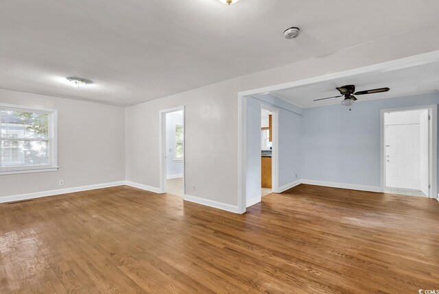 spare room featuring hardwood / wood-style flooring, ceiling fan, and a healthy amount of sunlight