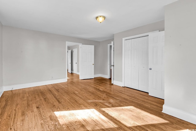 unfurnished bedroom featuring light hardwood / wood-style flooring and a closet