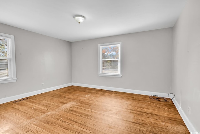 unfurnished room with hardwood / wood-style flooring and plenty of natural light