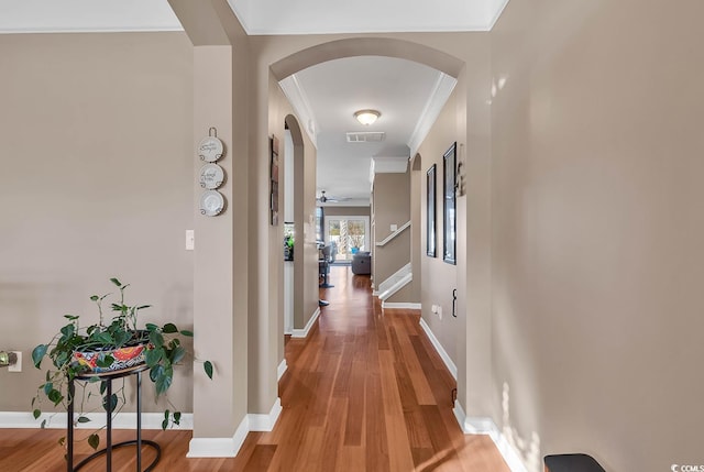 hall featuring wood-type flooring and ornamental molding