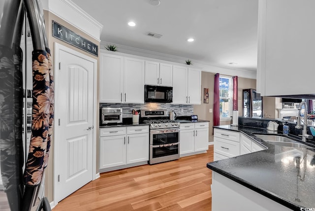 kitchen featuring white cabinets, light hardwood / wood-style floors, range with two ovens, and crown molding