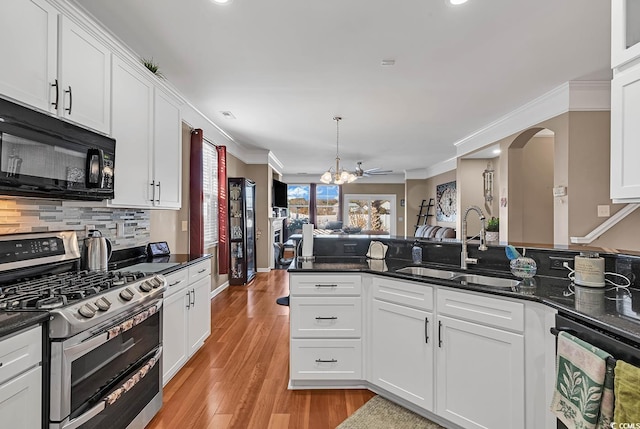 kitchen featuring white cabinets, crown molding, sink, stainless steel gas range, and light hardwood / wood-style floors