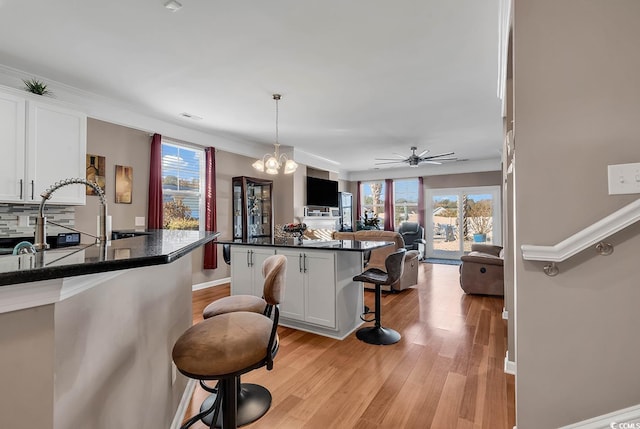 kitchen with white cabinetry, a breakfast bar, and plenty of natural light