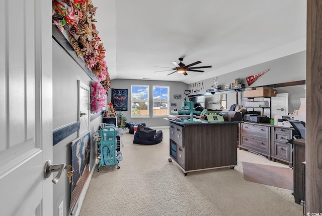 carpeted office space with ceiling fan and vaulted ceiling