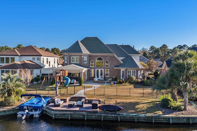 back of house with a playground and a water view