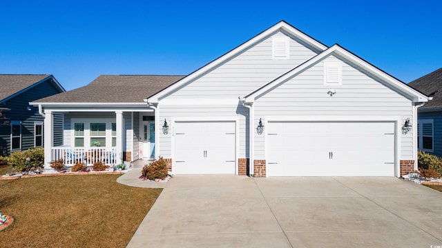 ranch-style house featuring covered porch, a front yard, and a garage