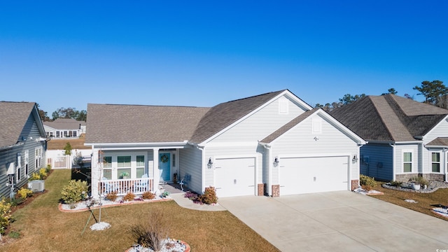 view of front of property with a porch, a garage, and a front lawn